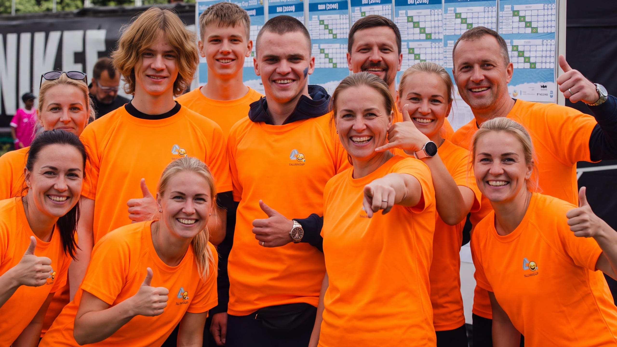 The Tallinn Cup office team in orange shirts by the fixture board