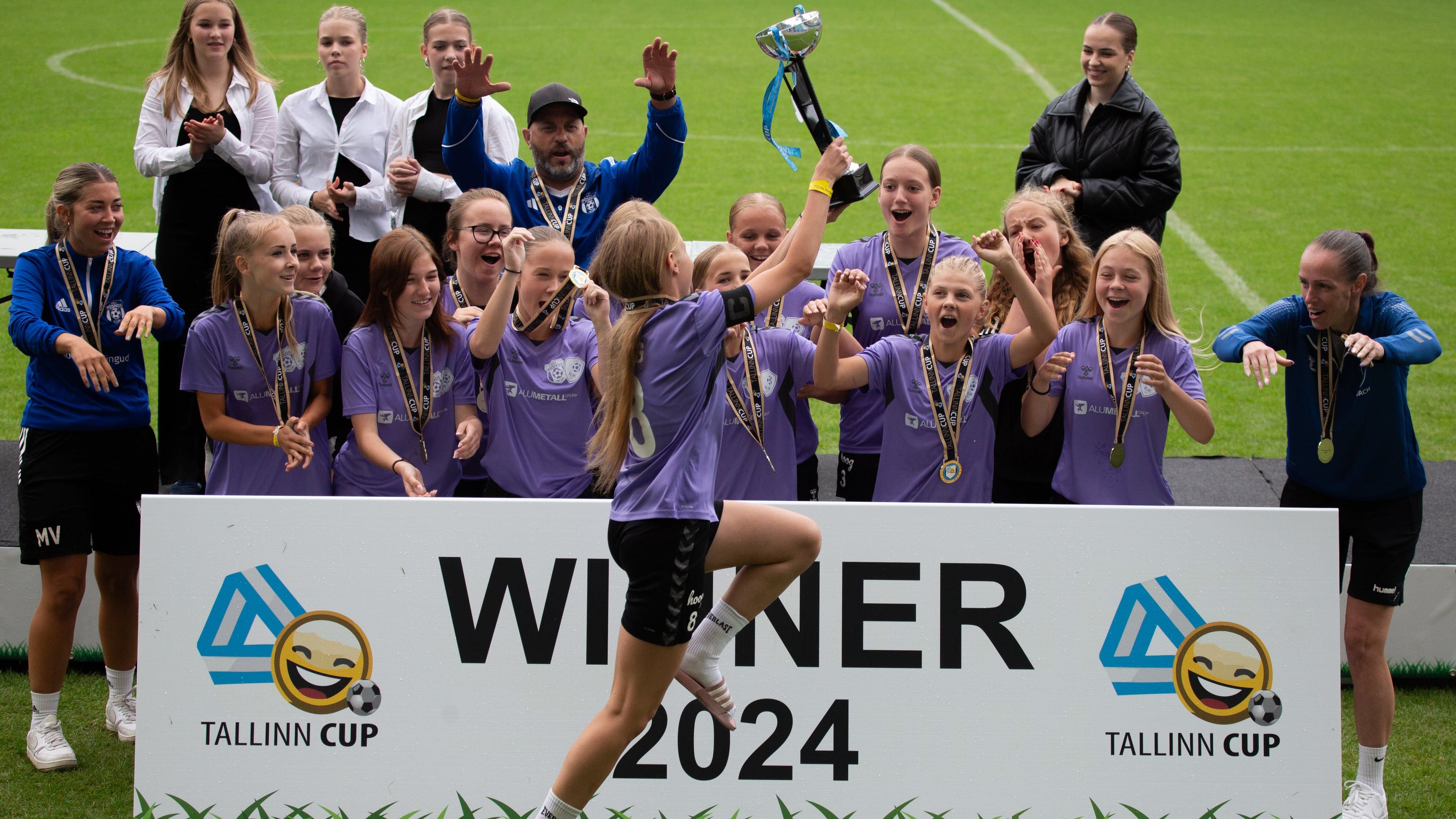 A girls' team lifting the Tallinn Cup trophy on the winners' podium